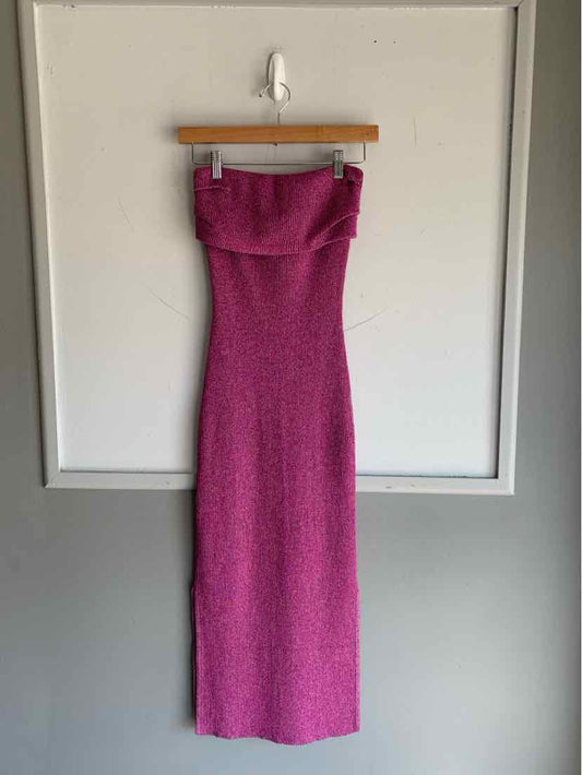 Sleeveless pink ribbed knit fitted midi dress with strapless neckline hanging on wooden hanger.