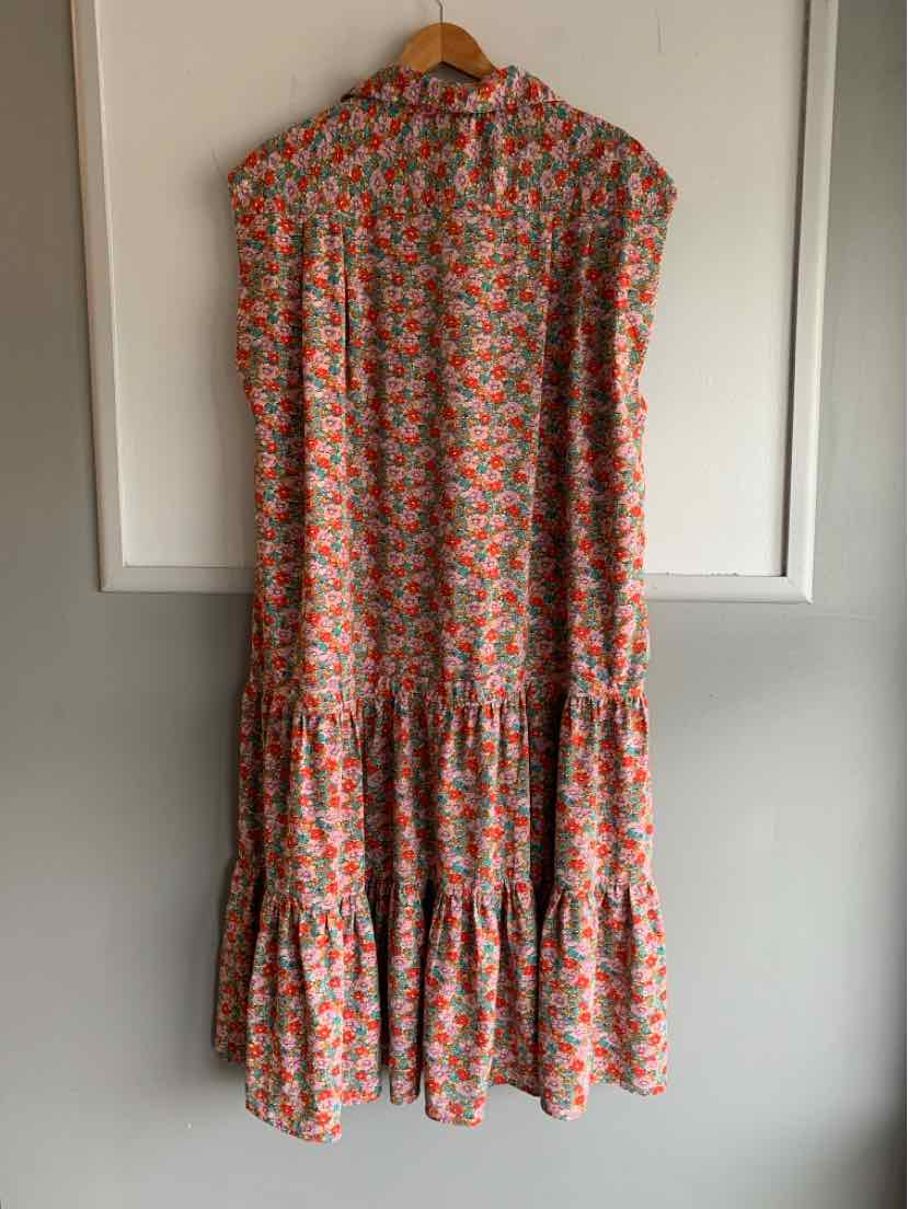 Sleeveless floral dress in orange, green, and white with tiered ruffle skirt, loose fit, and high neckline.