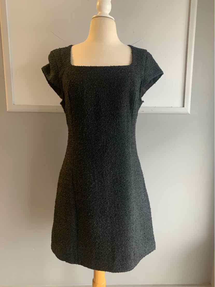 Black tweed mini dress with square neckline and short sleeves on mannequin.
