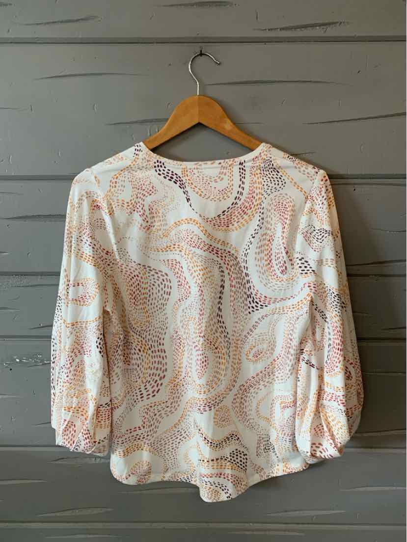White long-sleeve blouse with abstract peach and beige paisley pattern, round neckline, and gathered cuffs.