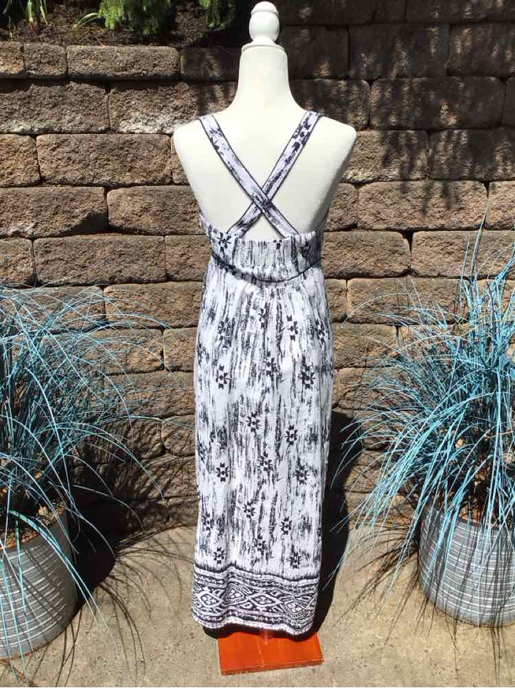 White and navy patterned maxi dress with crisscross straps and border print hem.