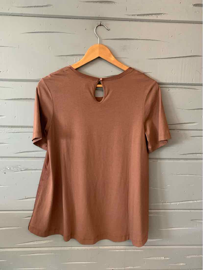 Soft brown short-sleeve blouse with keyhole back detail hanging on wooden hanger.