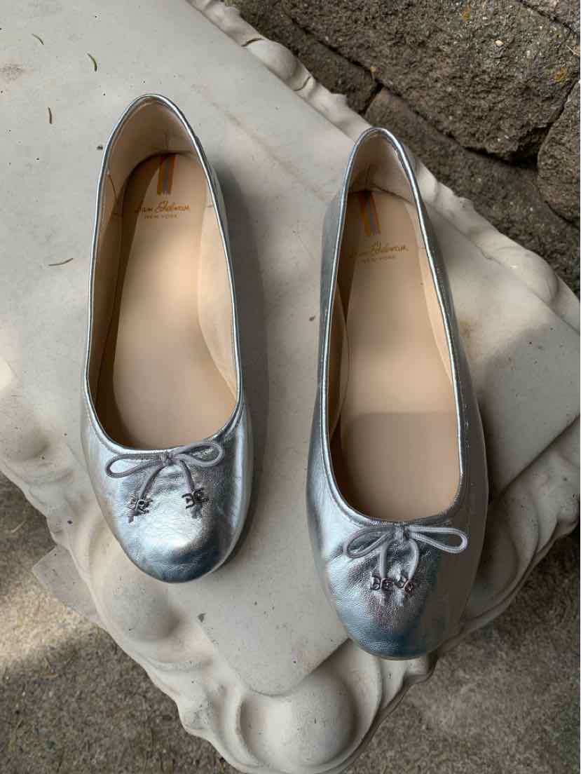Metallic silver ballet flats with rounded toes, small bows, and smooth leather finish, size 9.5.