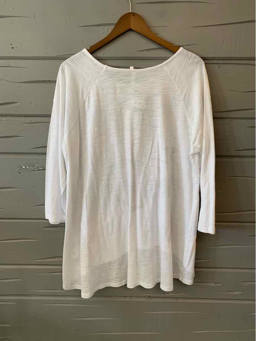 White long-sleeve loose-fit shirt with scoop neckline hanging on wooden hanger.
