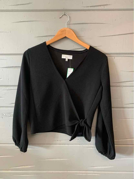 Black long-sleeve V-neck cropped wrap top with tie waist and slightly puffed sleeves.