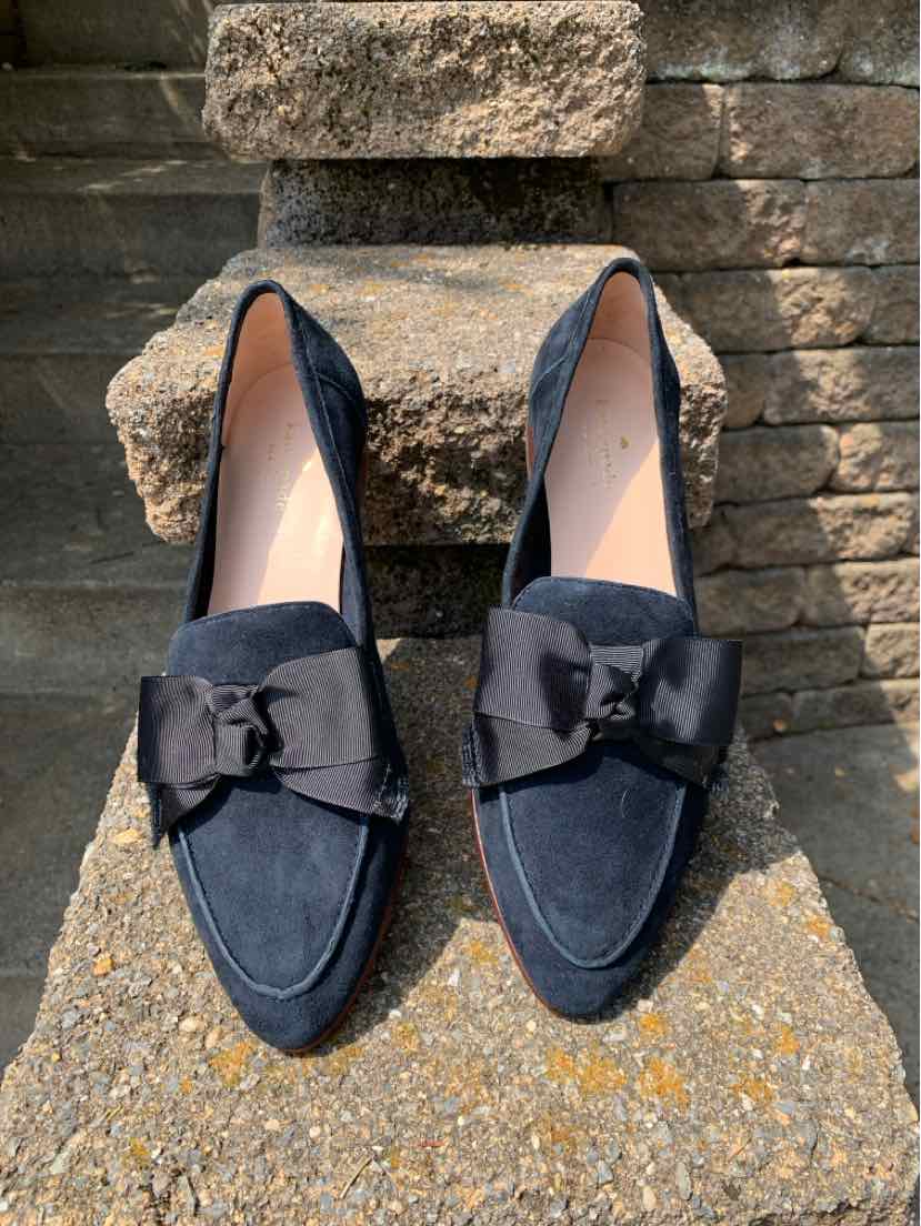 Black suede loafers with rounded toes and large bow accents on top, size 10.