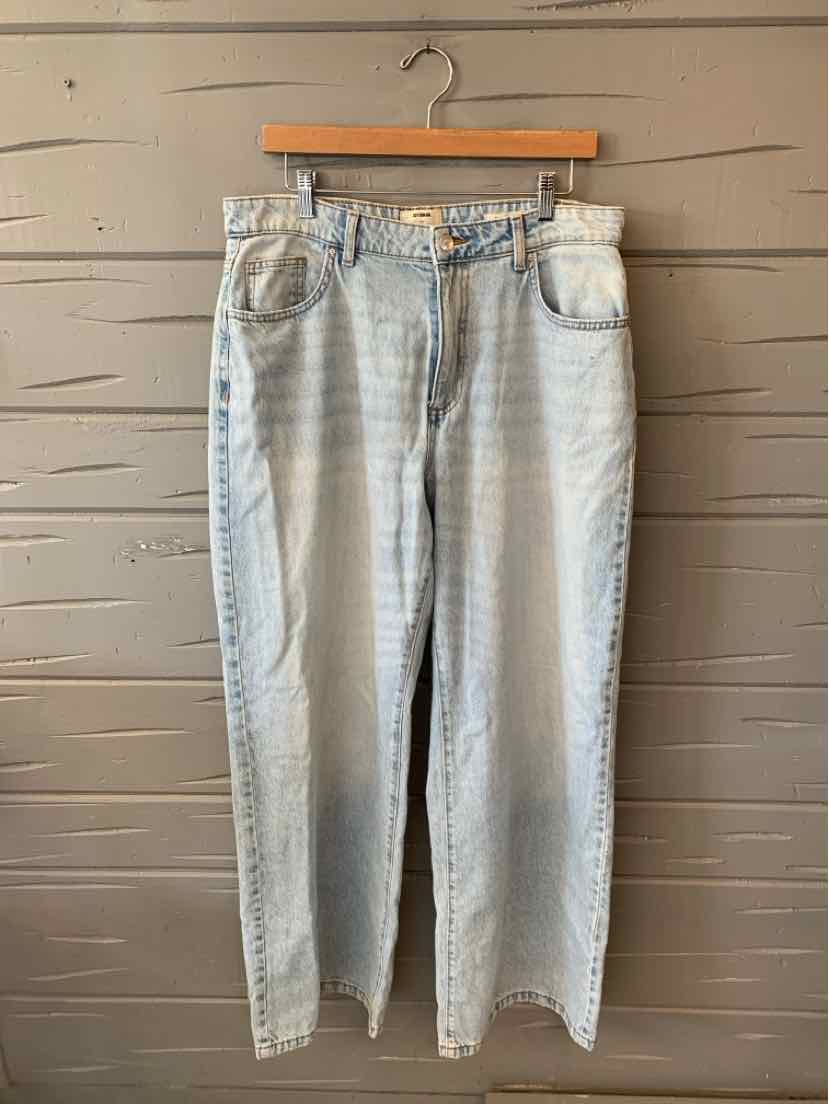 High-waisted light blue denim jeans with straight legs and classic five-pocket design hanging on wooden hanger.