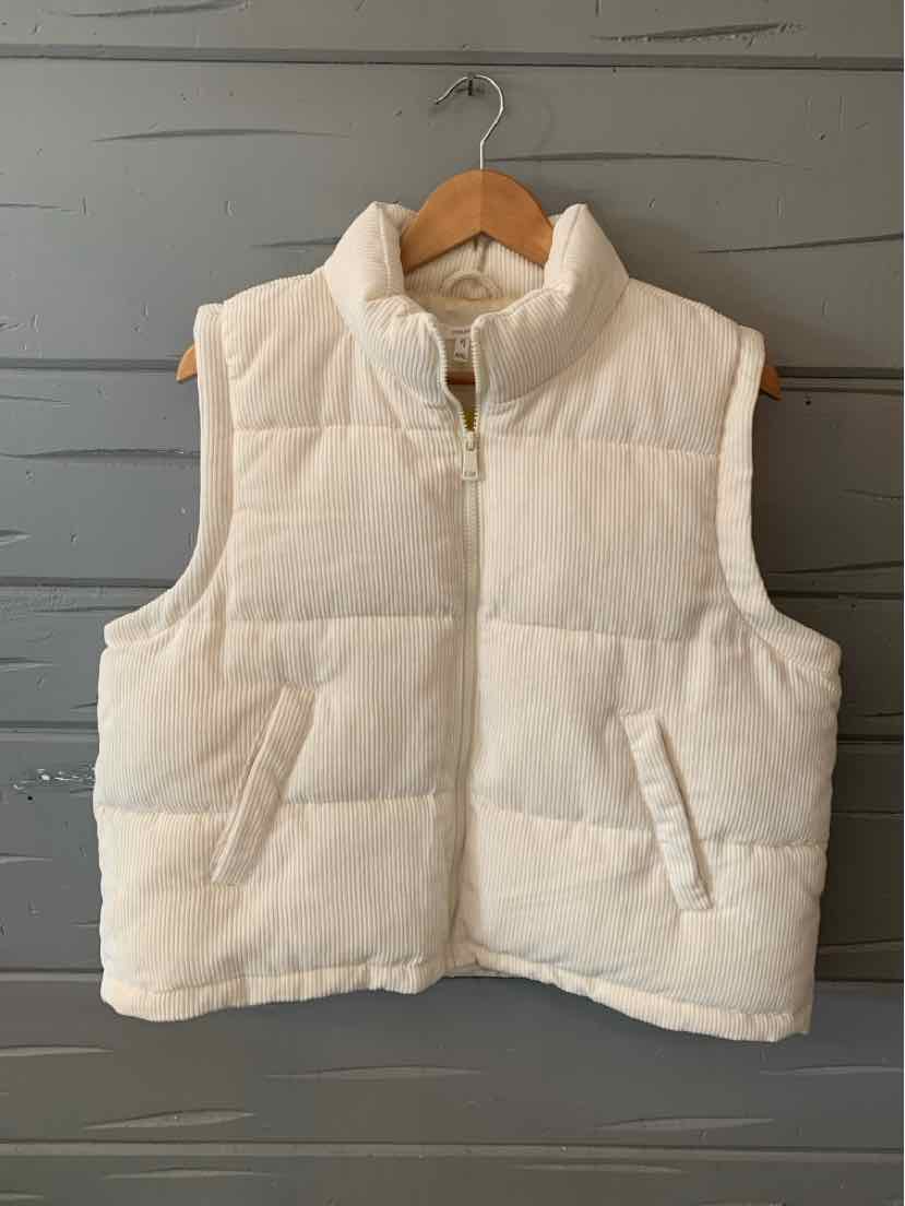 White quilted puffer vest with high collar and front pockets on wooden hanger.