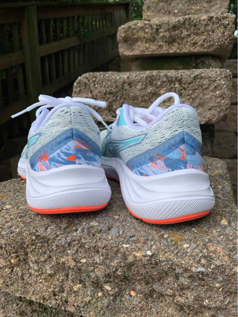 Pair of white athletic sneakers with light blue mesh and neon orange accents on thick soles, size 6.5.
