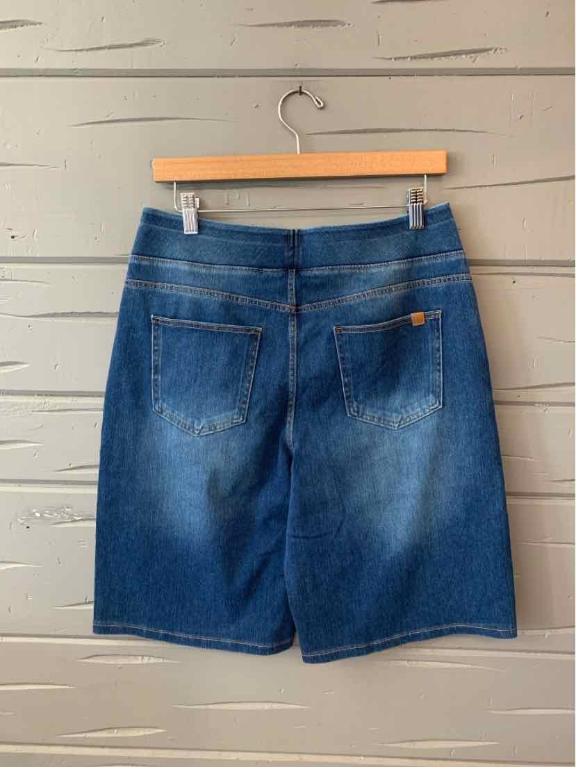 Blue denim skirt with two back pockets and belt loops hanging on wooden hanger.