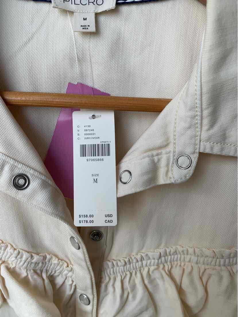 Cream-colored medium Pilcro shirt with snap buttons and gathered fabric detail below the chest.