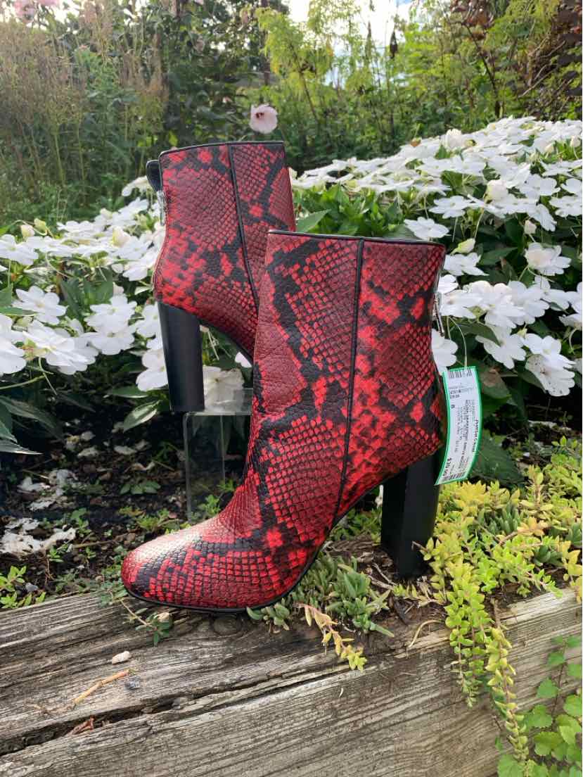 Red ankle boots with black snake print, pointed toes, and block high heels.