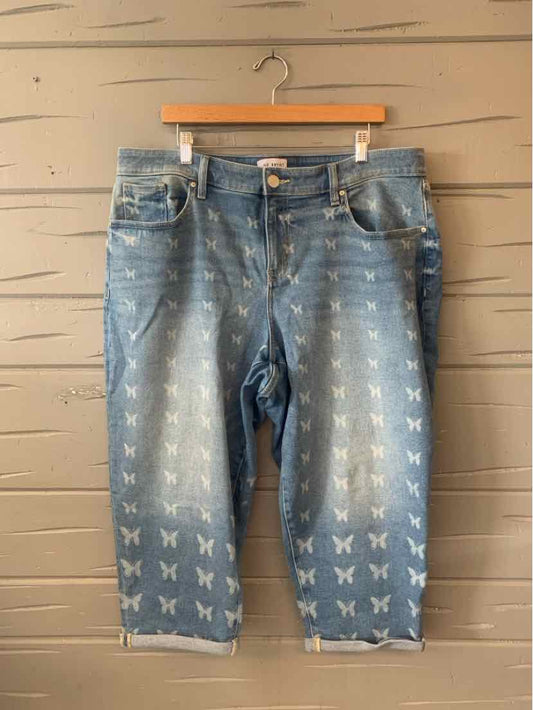 Light blue denim capri jeans with butterfly prints, button and zipper closure, and five-pocket styling.