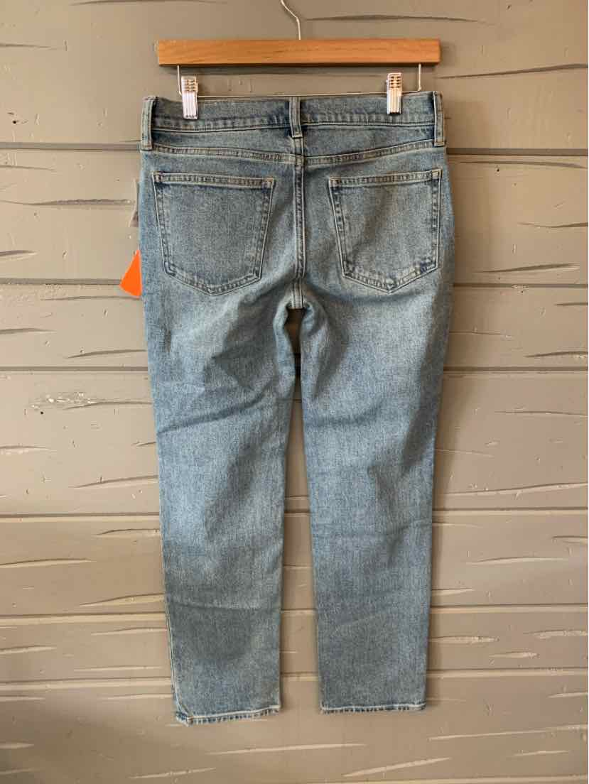 Light blue denim jeans with a straight leg cut and classic five-pocket design hanging on a wooden hanger.