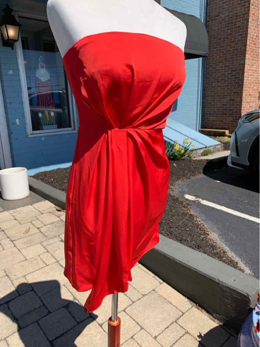 Strapless red satin mini dress with gathered detail at waist on mannequin outdoors.