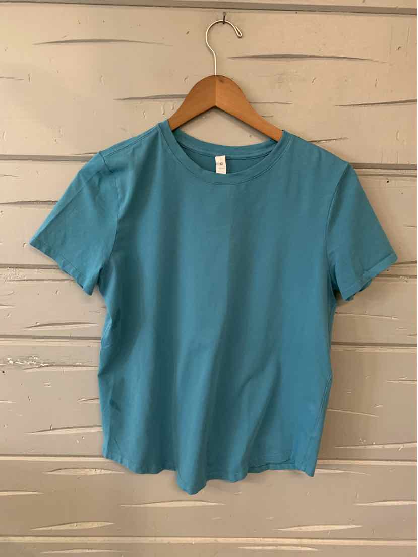 Teal short-sleeve crew neck shirt with slim fit, smooth fabric, size 6, hanging on wooden hanger.
