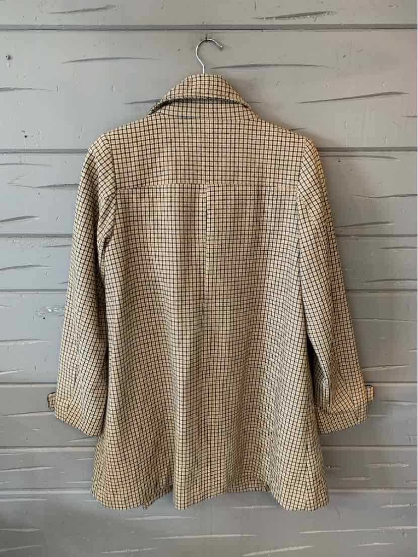 Tan plaid blazer with long sleeves and notched collar hanging on a wooden wall.