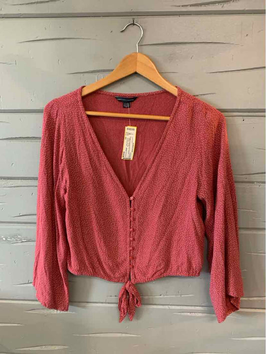 Red long-sleeve crop top with V-neck, button-down front, and front tie detail in lightweight fabric.