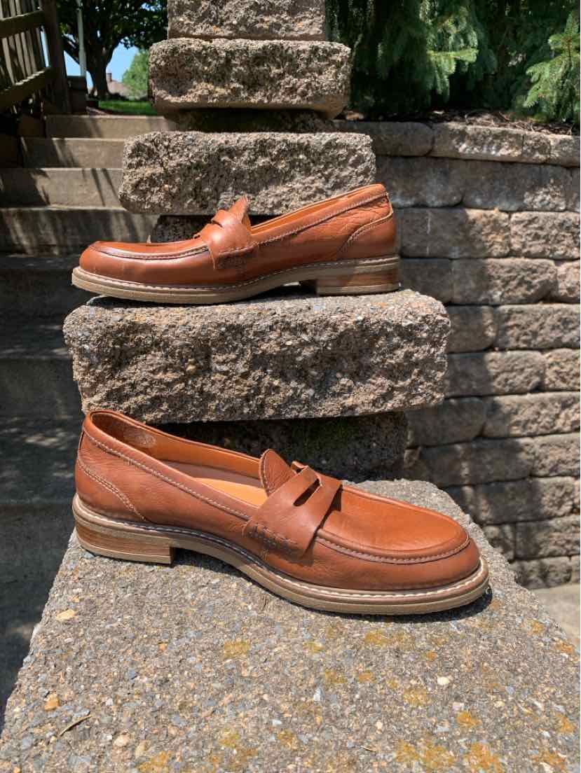Brown leather slip-on loafers with stitched detailing and low stacked heels.