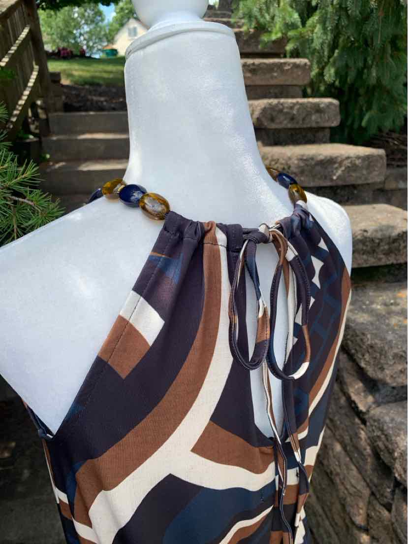 Sleeveless halter top with abstract geometric print in navy, brown, beige, and white, featuring a tied neckline and flowy.