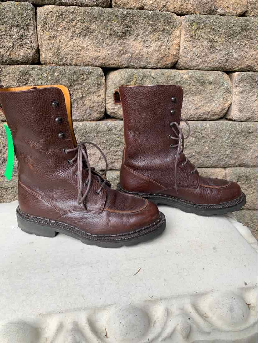 Dark brown leather mid-calf lace-up boots with rounded toes and sturdy black soles.