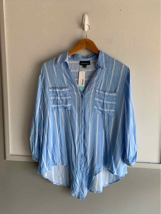 Light blue button-up shirt with white vertical stripes and chest pockets on wooden hanger.
