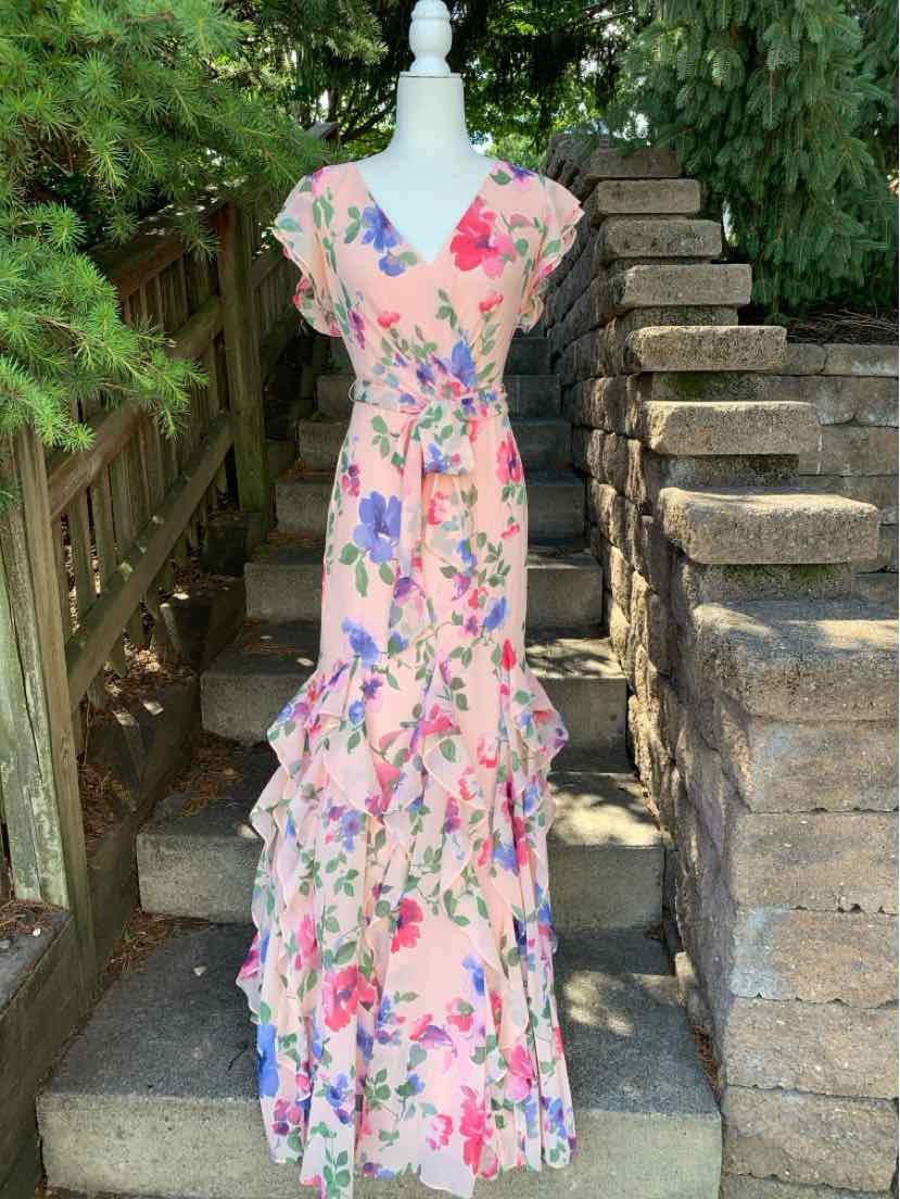 Pink floral maxi dress with V-neck, short sleeves, and tiered ruffle skirt on mannequin outdoors.