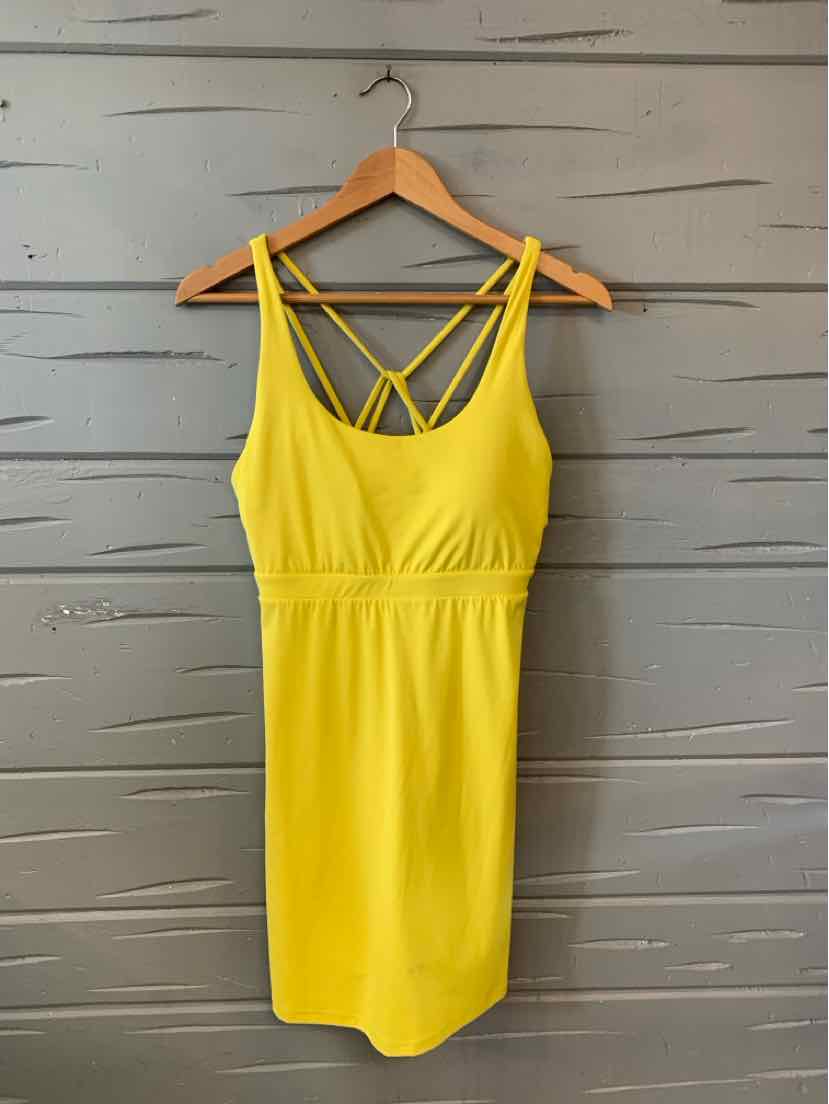 Bright yellow sleeveless dress with fitted waist and crisscross straps on back.
