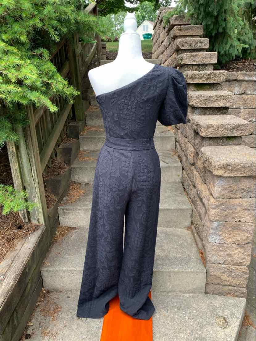Black one-shoulder jacquard jumpsuit with short puff sleeve and wide legs.
