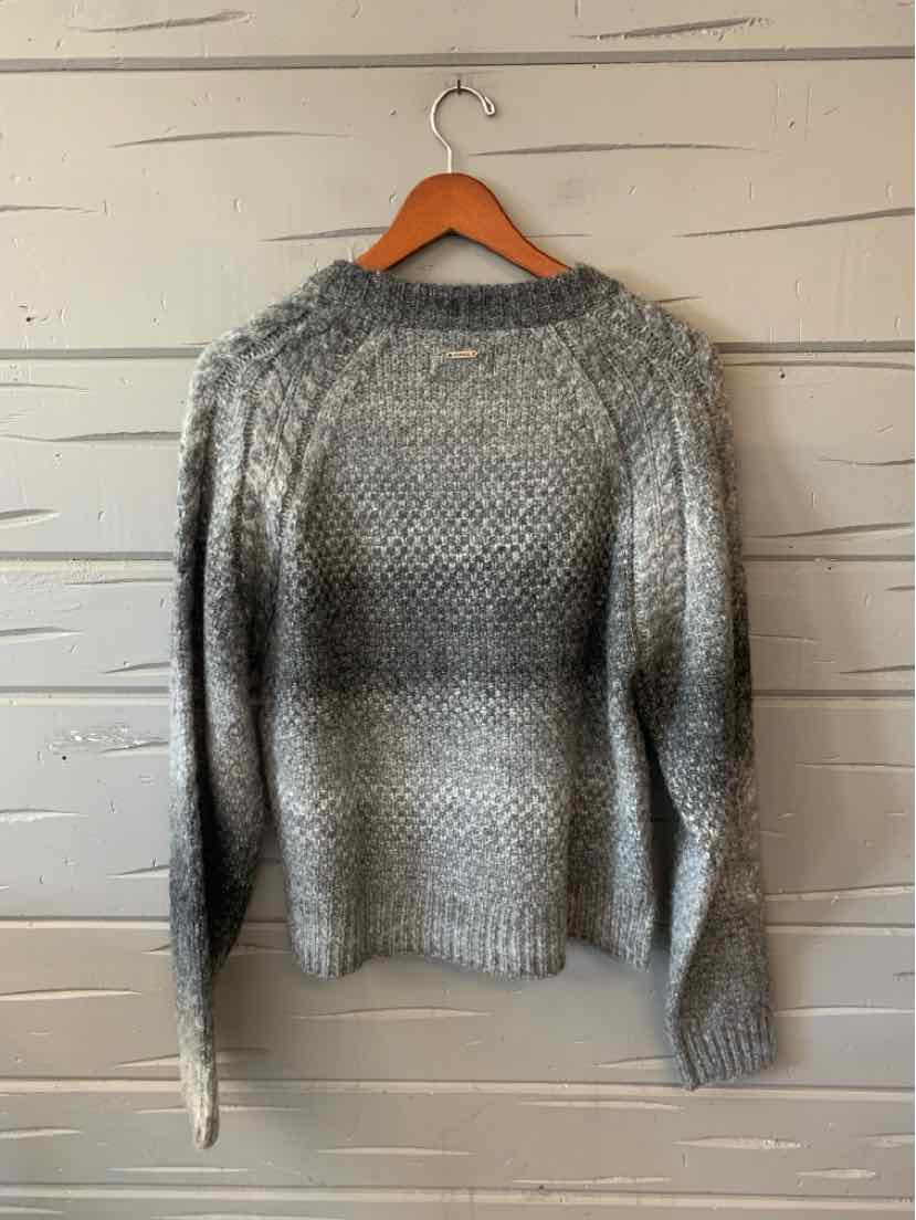 Gray marled knit crewneck sweater with long sleeves and a relaxed fit, hanging on a wooden hanger.