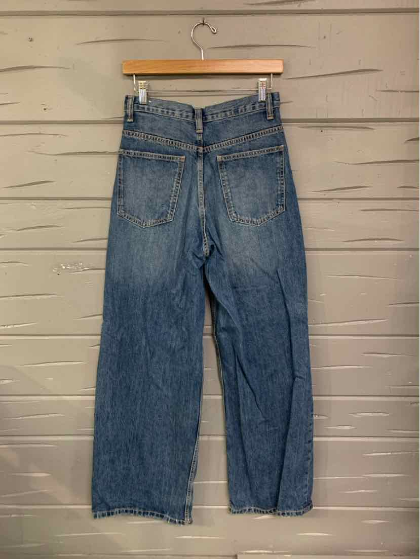 Blue denim high-waist jeans with straight legs and back patch pockets on wooden hanger.