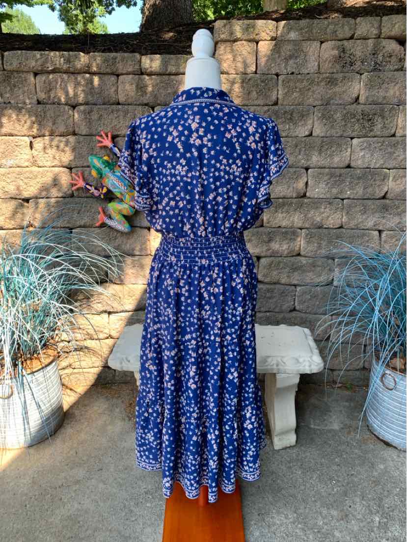 Blue midi dress with white floral print, short sleeves, and gathered waist detailing.