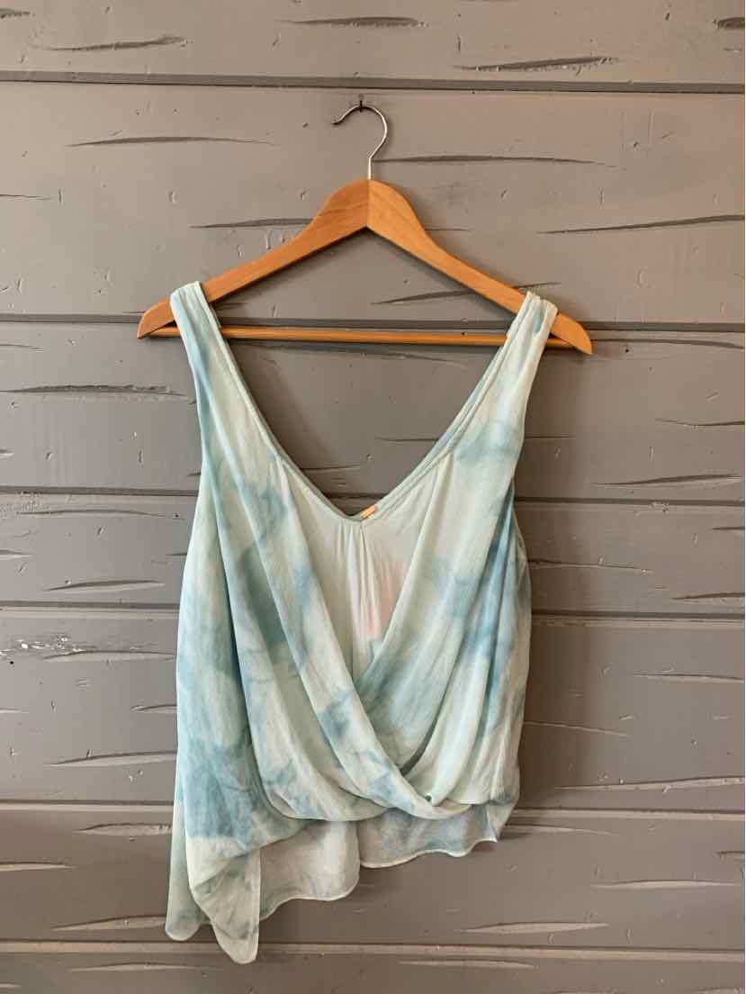 Light blue and white tie-dye sleeveless wrap top with deep V-neck and asymmetrical hem on wooden hanger.