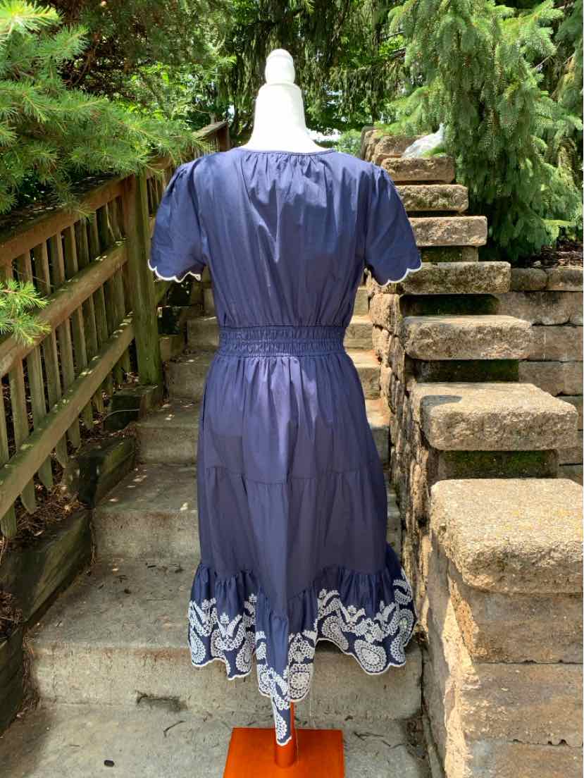 Navy blue midi dress with puff sleeves and eyelet scalloped hem detailing.