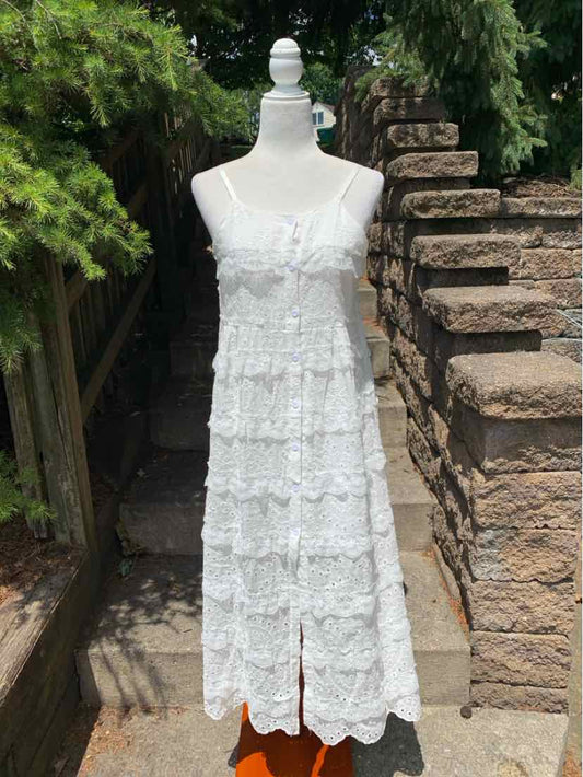 White sleeveless eyelet midi dress with tiered ruffles and front slit.
