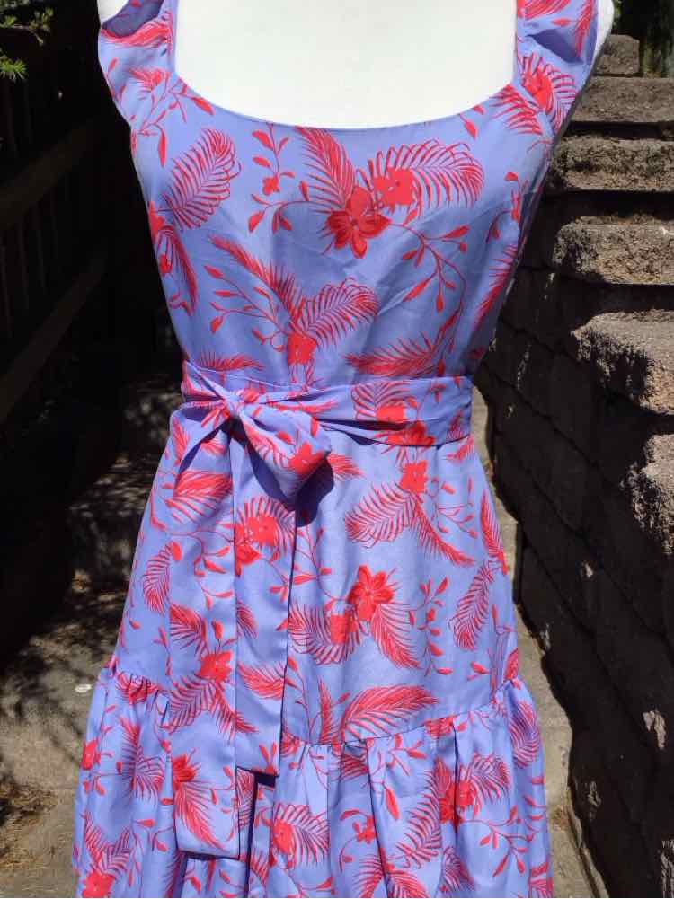 Light purple sleeveless sundress with red tropical floral print and a waist tie belt.