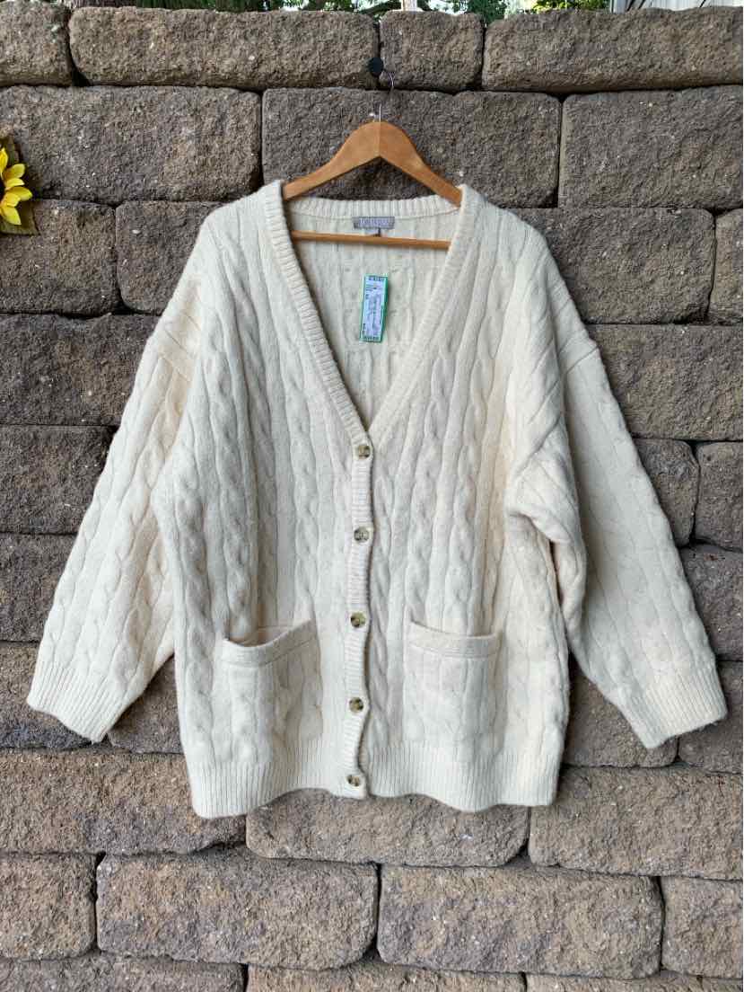 Cream-colored cable knit cardigan with large buttons and two front pockets, medium to large size.