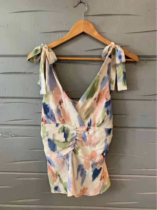 Floral print dress with pastel pink, green, and blue brushstroke pattern, tie straps, and ruched waist in medium size.