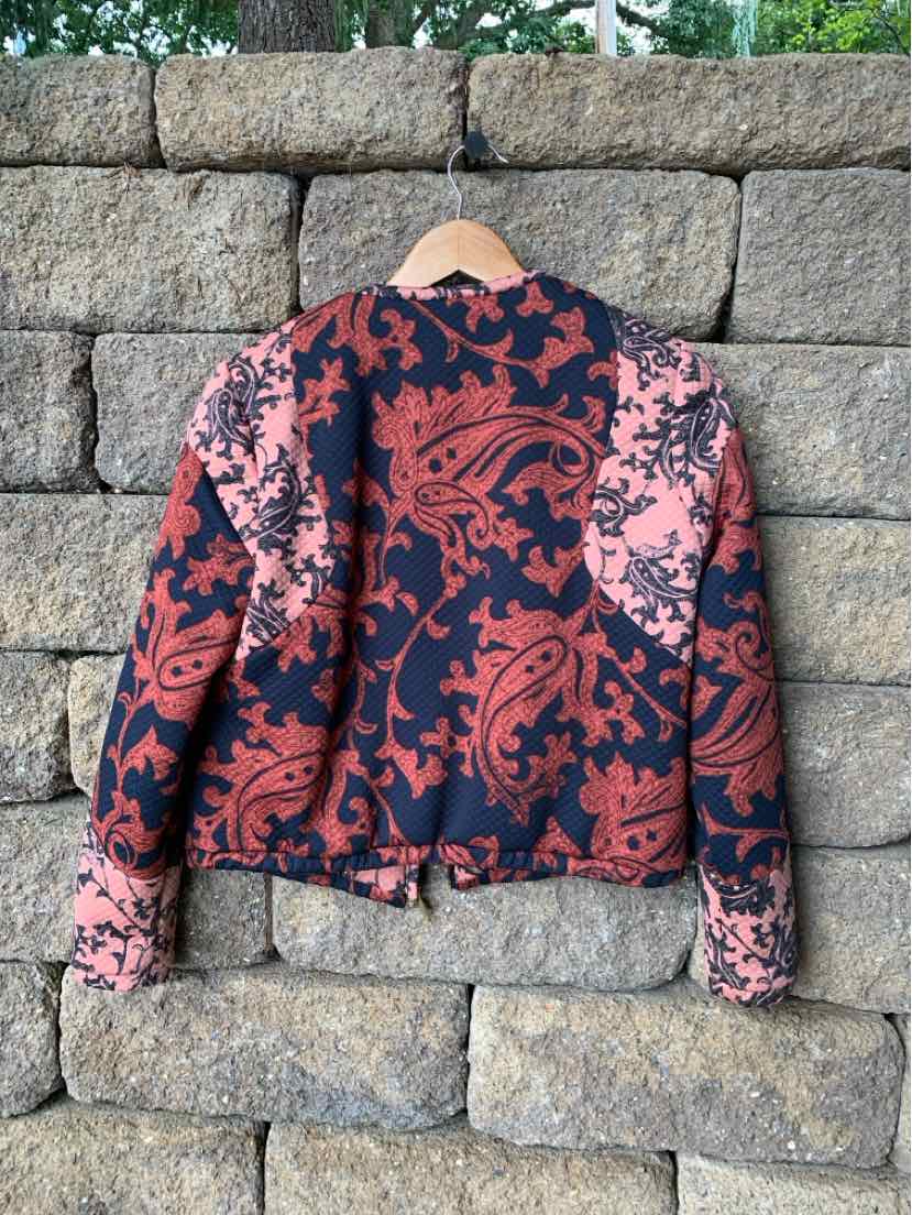 Black and pink paisley patterned long-sleeve jacket with a collar and buttoned cuffs.