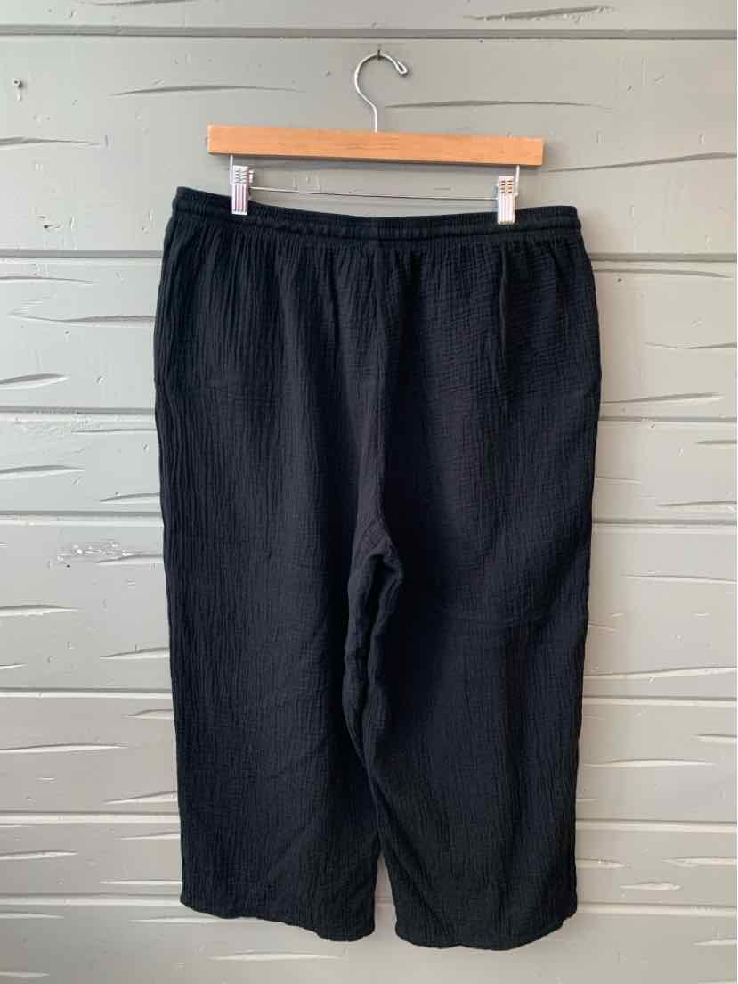 Black elastic waist casual pants with loose fit, size XL, hanging on wooden hanger.