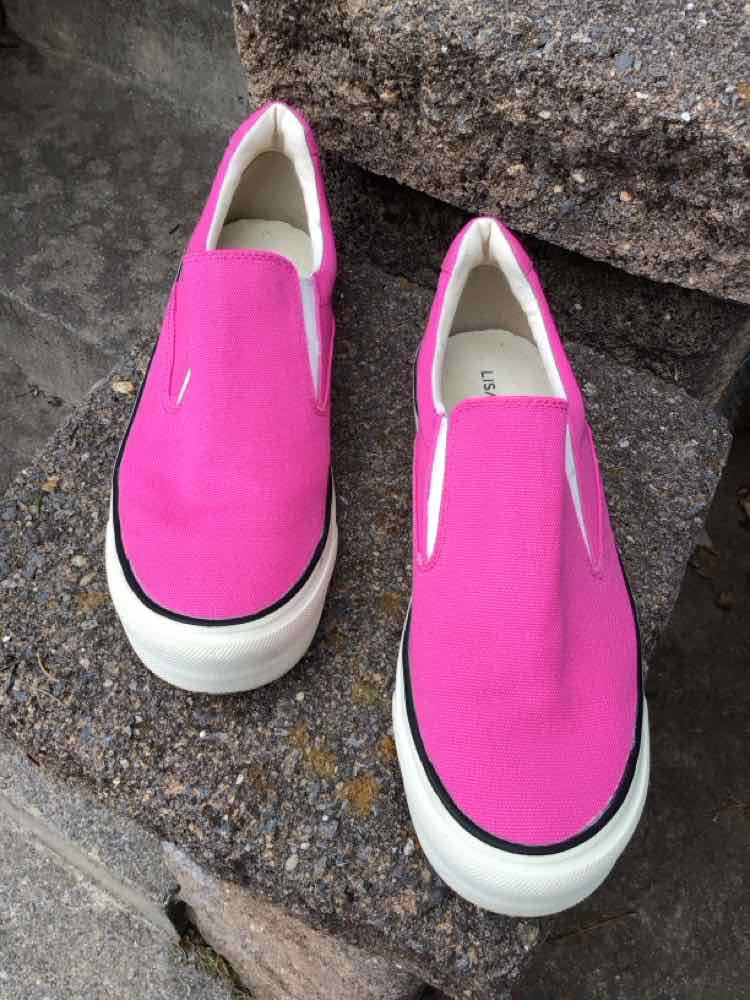 Bright pink slip-on sneakers with white platform soles and black trim around the base.