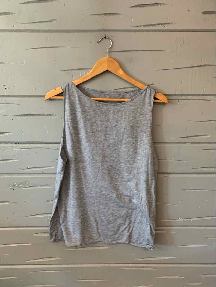 Gray sleeveless tank top with side slits on wooden hanger against gray wooden wall.