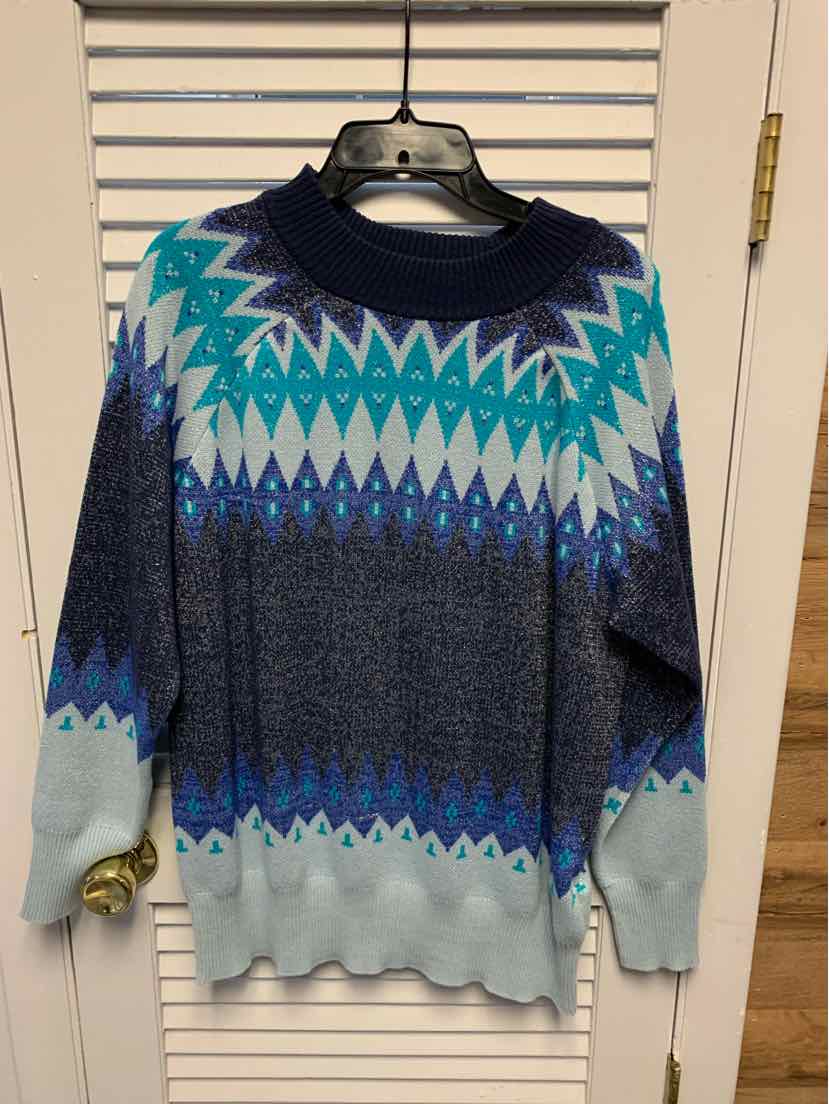 Long-sleeve knit sweater with blue, teal, and white geometric patterns and ribbed cuffs and hem.