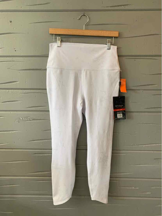 White solid high-waist athletic leggings with a fitted silhouette and ankle length, featuring Spyder logo tags on the side.