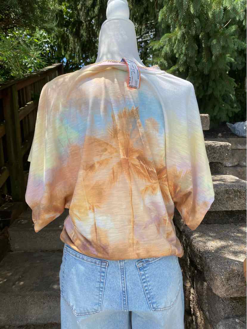 Loose-fit cropped hoodie with pastel tie-dye in orange, blue, and yellow on soft fabric.