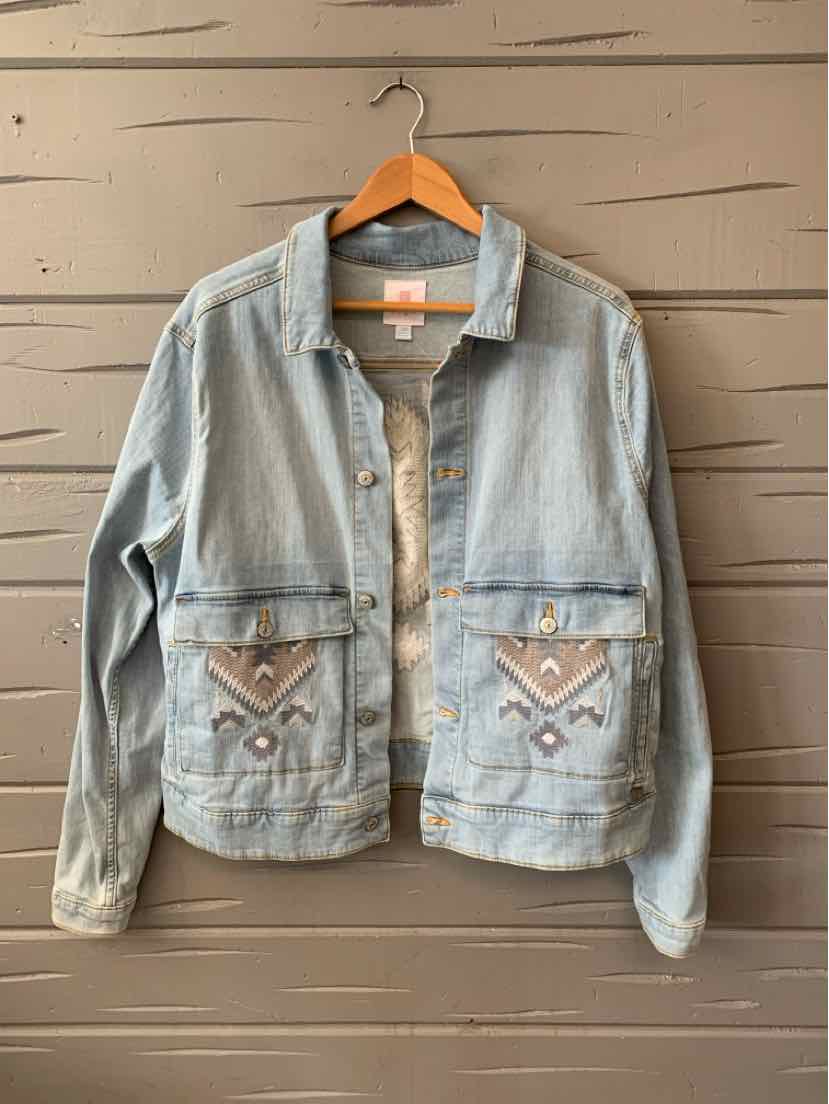 Light blue denim jacket with button-up front and two front pockets featuring tan and white chevron embroidery.