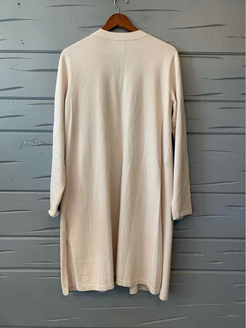 Long cream-colored cardigan with a soft, lightweight knit and long sleeves hanging on a wooden hanger.