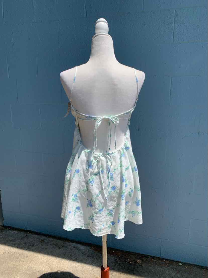 White floral spaghetti strap dress with open back and tie closure, short length.