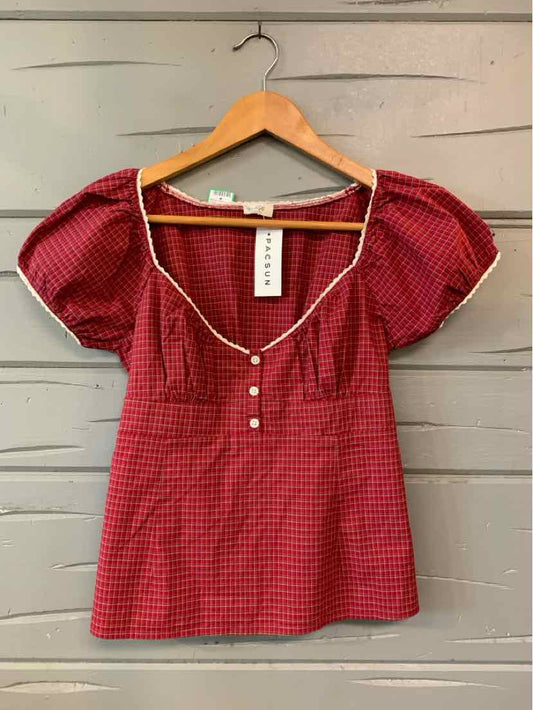 Red plaid short-sleeve blouse with puffed sleeves and white buttons down the front.