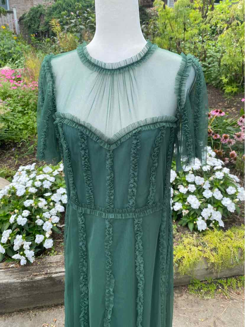 Dark green short-sleeve dress with sheer yoke and intricate beaded detailing, fitted waist.
